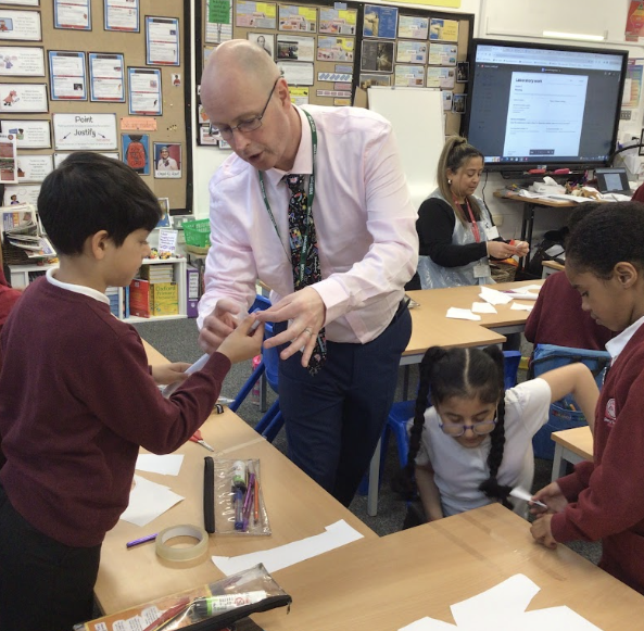 Dan Sullivan working with primary pupils during a hands-on science lesson in the classroom