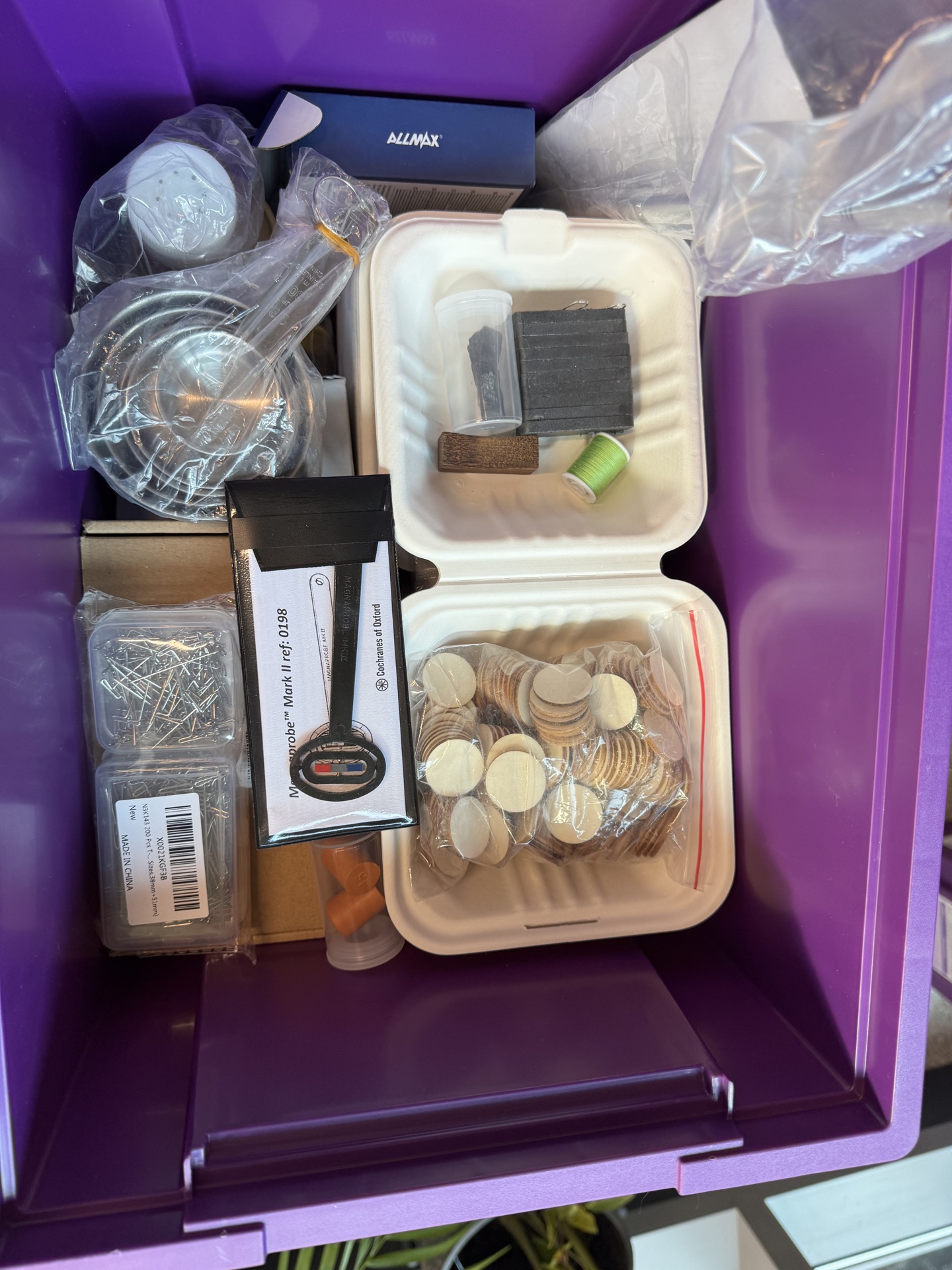Inside a purple science kit box: magnets, wooden discs, wire and practical equipment