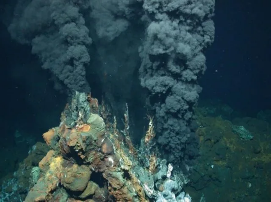 A hydrothermal vent billowing black smoke on the ocean floor