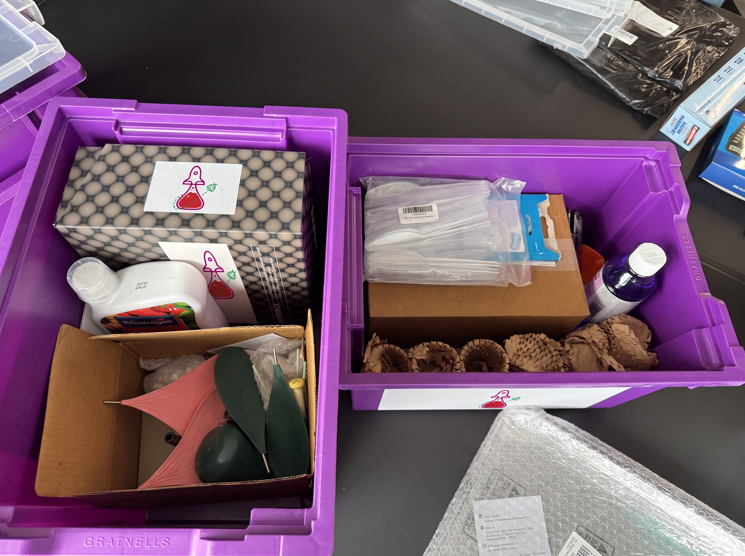 Open ABC Science purple boxes showing a flower model, bottles, pipettes and packaged science materials